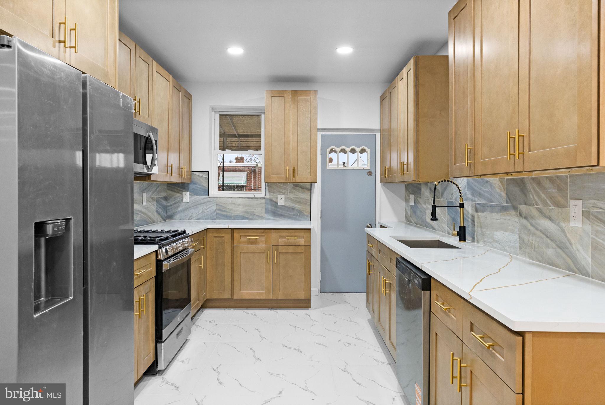 7331 East Walnut Lane Philadelphia, PA 19138 - Photo 11 of 49 a kitchen with stainless steel appliances granite countertop a sink a stove and a refrigerator