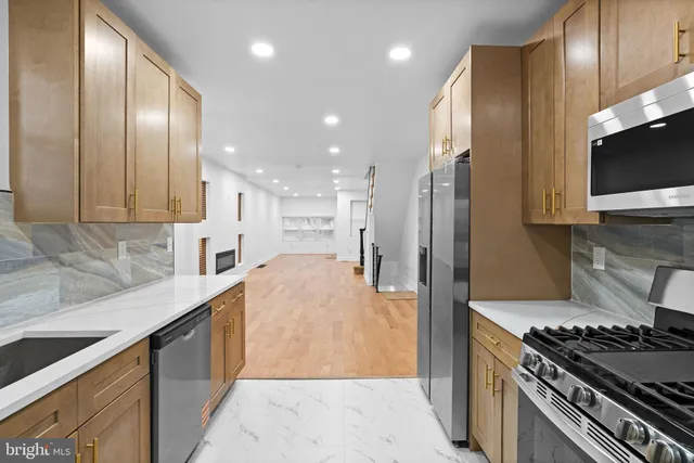 a kitchen with stainless steel appliances granite countertop a sink stove and refrigerator