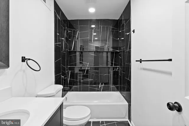 a bathroom with a sink toilet vanity and shower