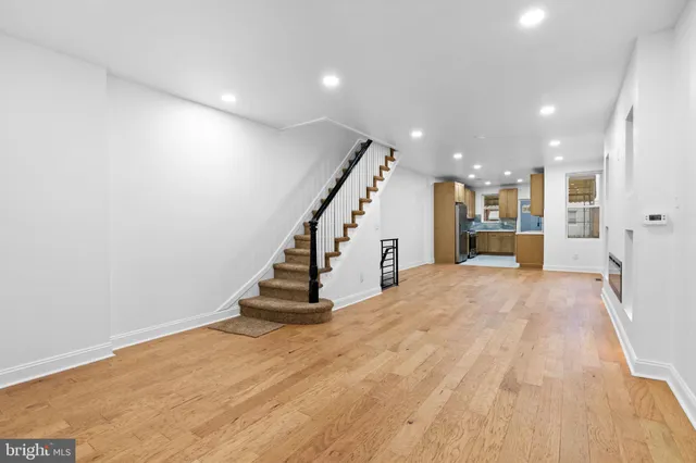 a view of a hallway with wooden floor and staircase