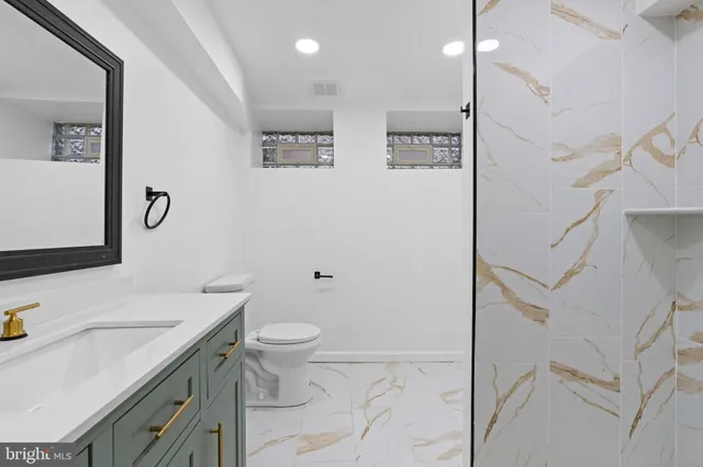a bathroom with a shower sink vanity and mirror