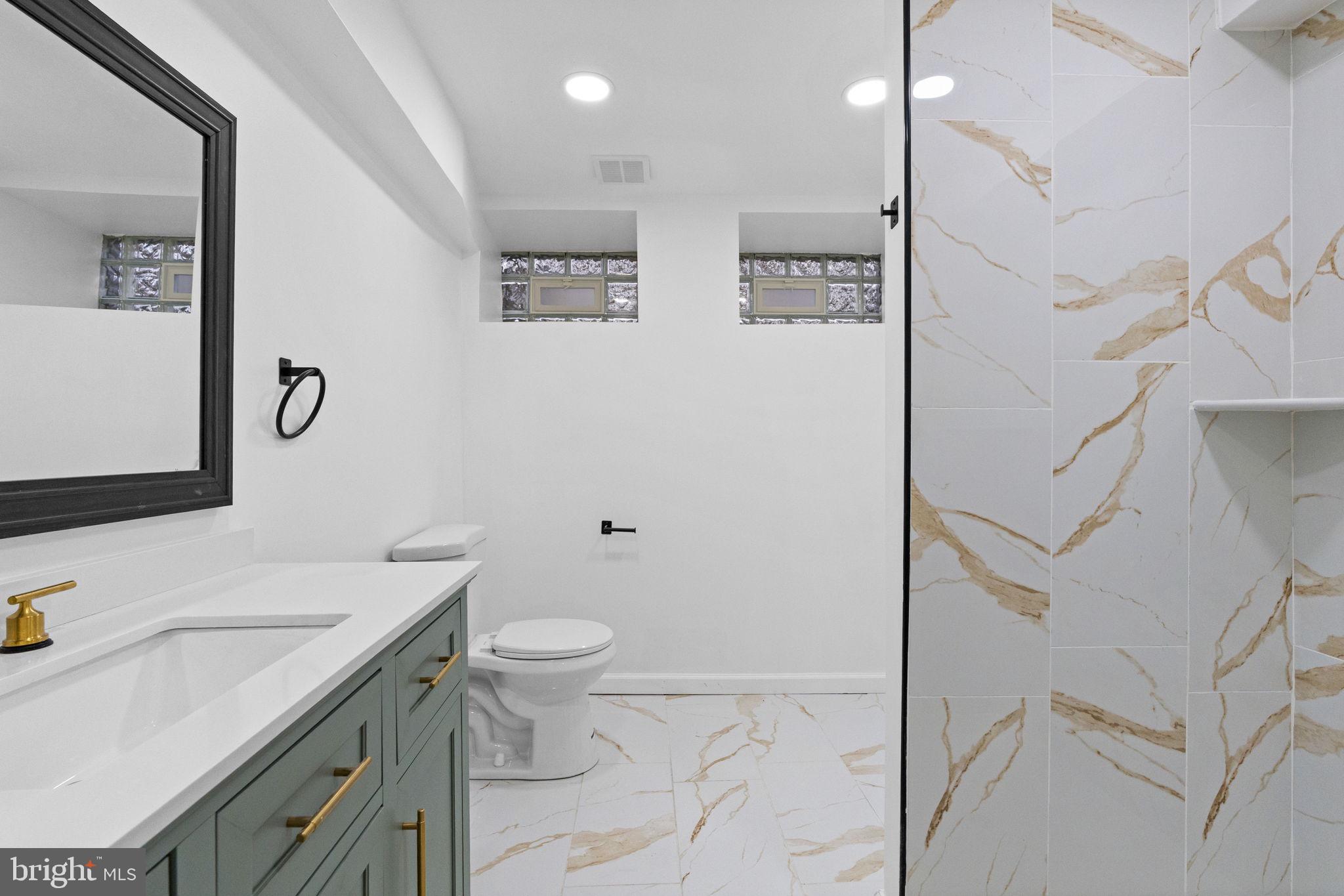7331 East Walnut Lane Philadelphia, PA 19138 - Photo 45 of 49 a bathroom with a granite countertop sink a toilet and a mirror