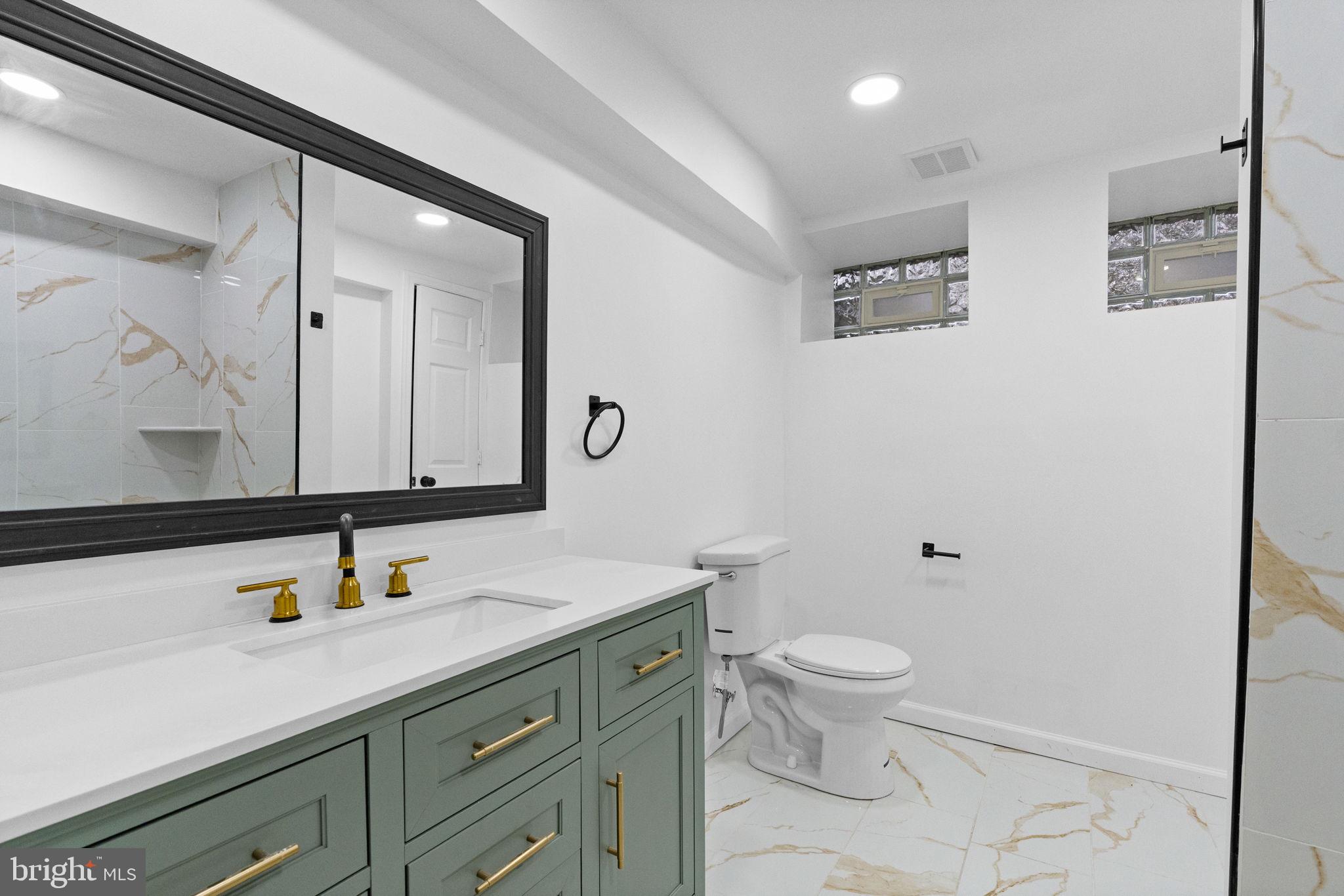 7331 East Walnut Lane Philadelphia, PA 19138 - Photo 46 of 49 a bathroom with a sink a toilet and a mirror