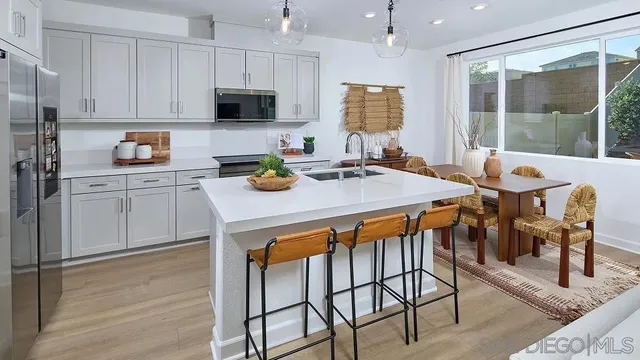 a kitchen with a dining table chairs and refrigerator