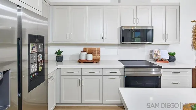 a kitchen with white cabinets stainless steel appliances and sink