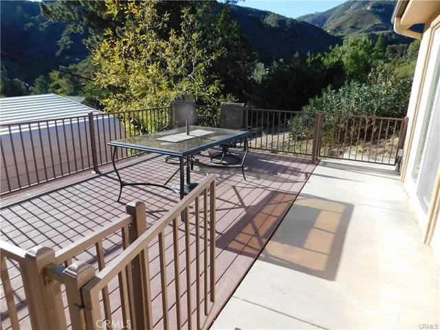 a view of a balcony with chairs and wooden fence