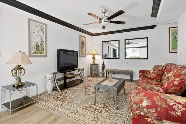 a living room with furniture and a flat screen tv with wooden floor