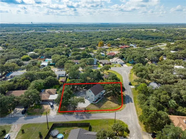 an aerial view of residential houses with outdoor space and trees