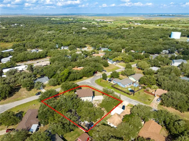 an aerial view of residential houses with outdoor space and trees