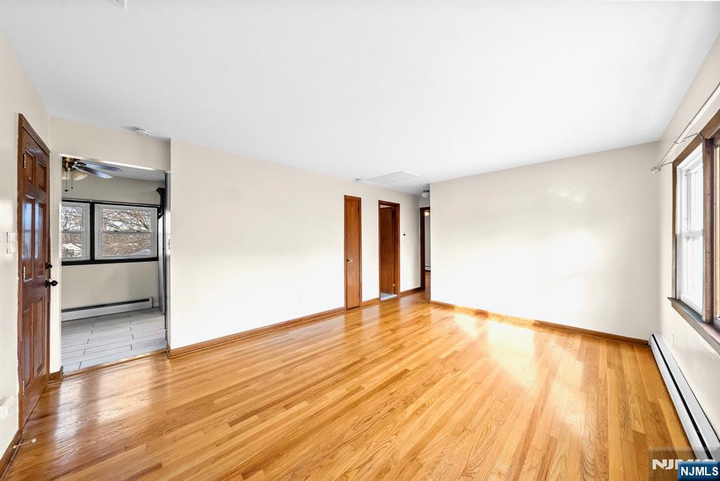 468 Broughton Avenue Bloomfield, NJ 07003 - Photo 5 of 15 an empty room with wooden floor and windows