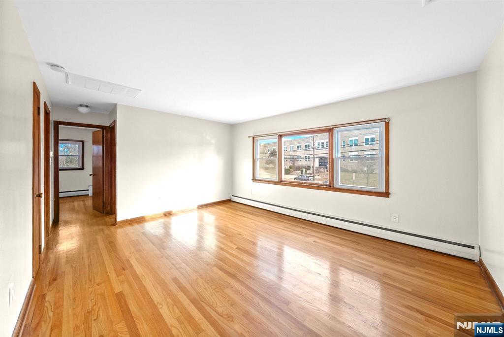 468 Broughton Avenue Bloomfield, NJ 07003 - Photo 6 of 15 an empty room with wooden floor and windows