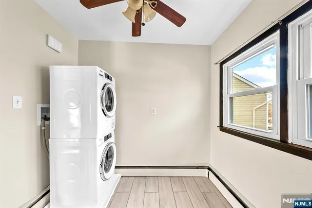a view of a room with a ceiling fan and wooden floor