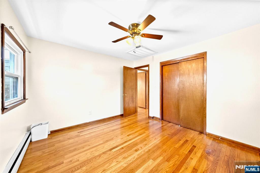 468 Broughton Avenue Bloomfield, NJ 07003 - Photo 10 of 15 a view of a room with a ceiling fan and wooden floor