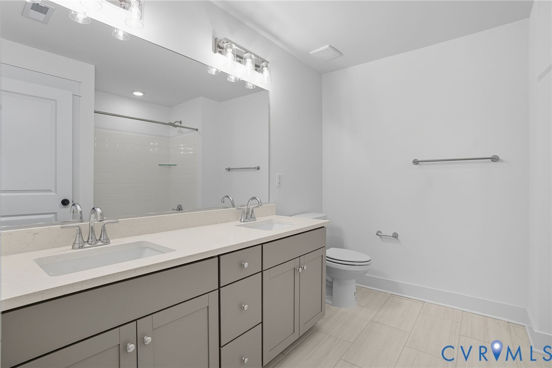 3731 Tuckmar Ridge Drive Moseley, VA 23120 - Photo 17 of 27 a bathroom with a double vanity sink toilet and a mirror