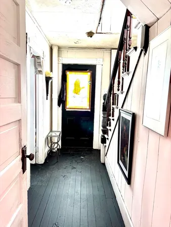 a view of a hallway with wooden floor and staircase