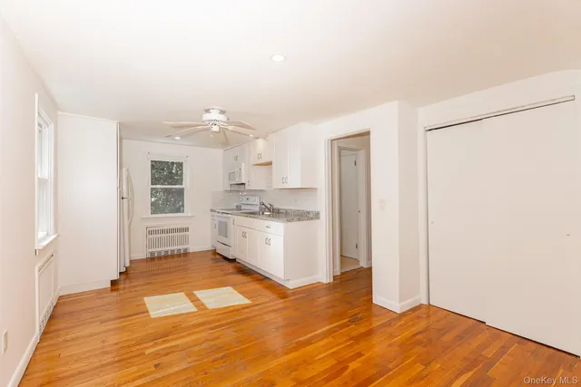 a room with a white cabinets and wooden floor