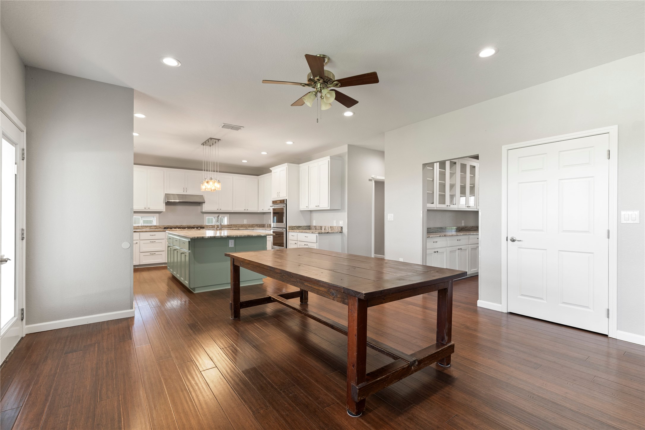 1293 Pioneer Road Seguin, TX 78155 - Photo 8 of 40 Rich hardwood floors flow through this open-concept kitchen and dining area, creating a seamless space for entertaining.