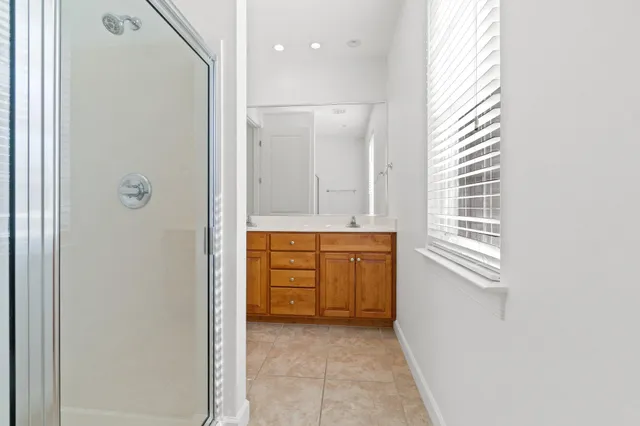 a bathroom with a granite countertop sink a mirror and a shower
