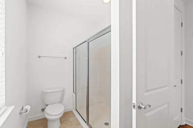 a bathroom with a toilet and a shower