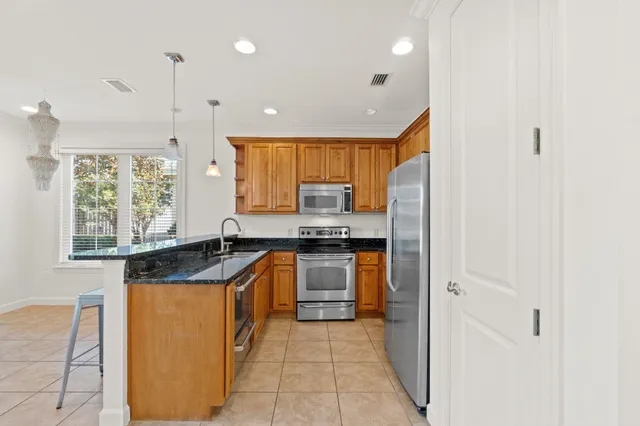 a kitchen with granite countertop a sink and a refrigerator