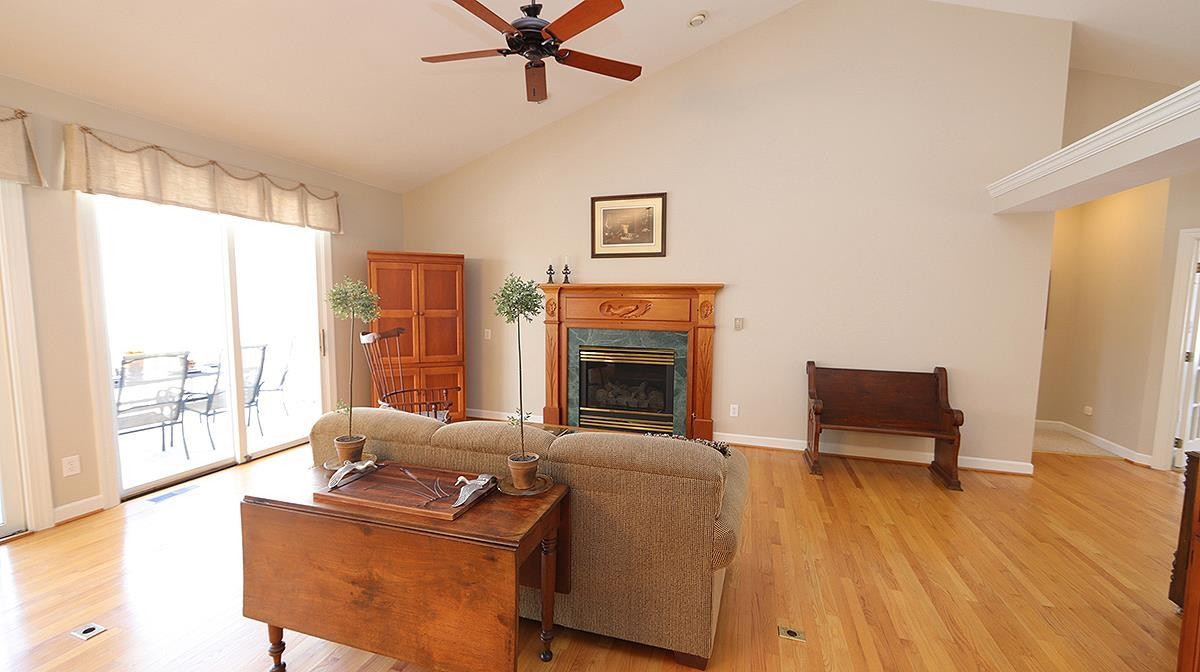 Gas log fireplace surrounded by hand carved mantel.