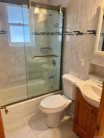 a white toilet sitting next to a bath tub and shower