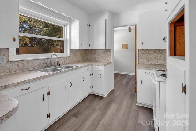 a spacious bathroom with a double vanity sink a mirror and a window
