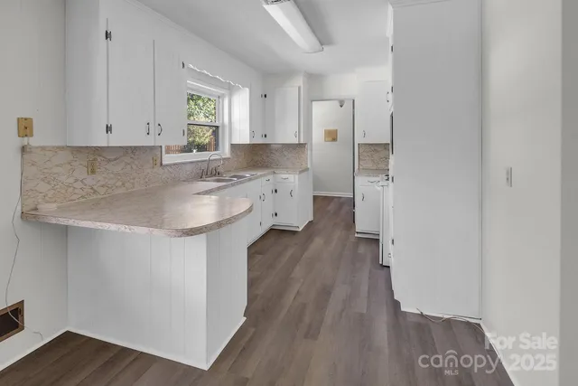 a kitchen with a sink and wooden floor