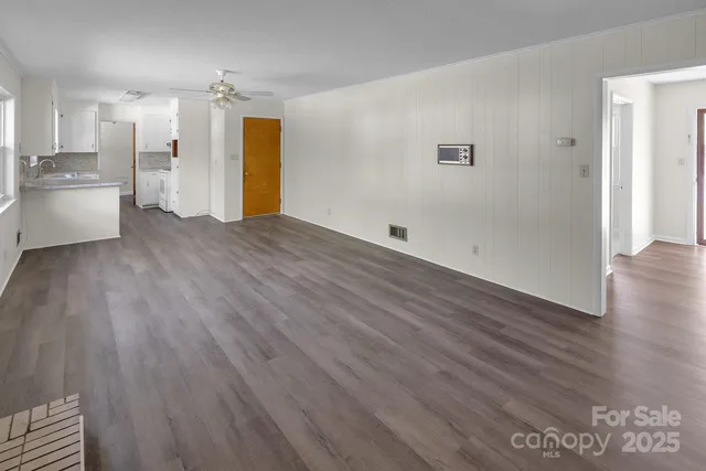 a view of a kitchen with wooden floor and electronic appliances