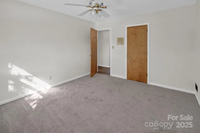 a view of a room with a ceiling fan and closet area