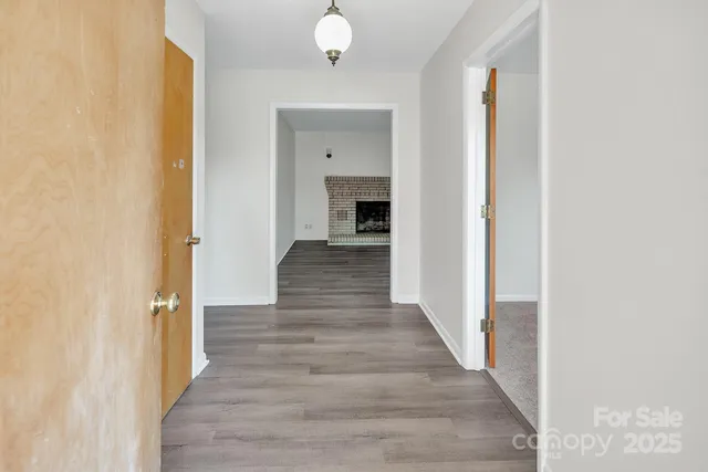 a view of a hallway with wooden floor and staircase