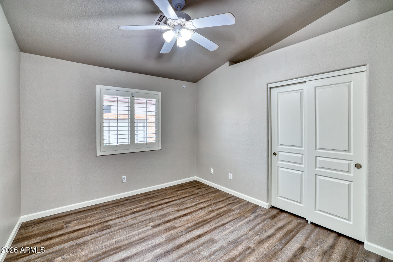 2206 East Ruby Lane Phoenix, AZ 85024 - Photo 20 of 29 an empty room with wooden floor chandelier fan and windows