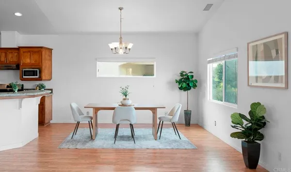 a dining room with furniture a large window and wooden floor