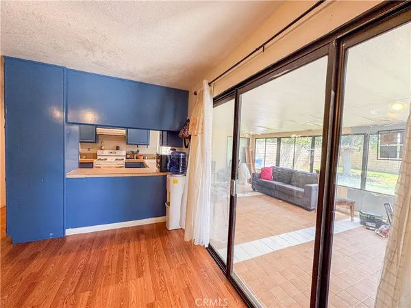 a view of a kitchen with wooden floor and electronic appliances