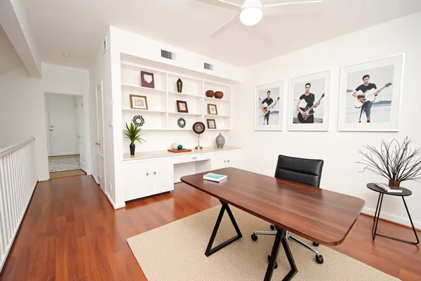 a view of a workspace with furniture and wooden floor