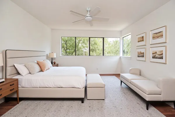 a bedroom with a bed couch and a large window