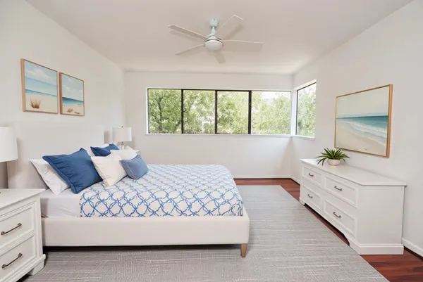 a bedroom with a large bed and a chandelier fan