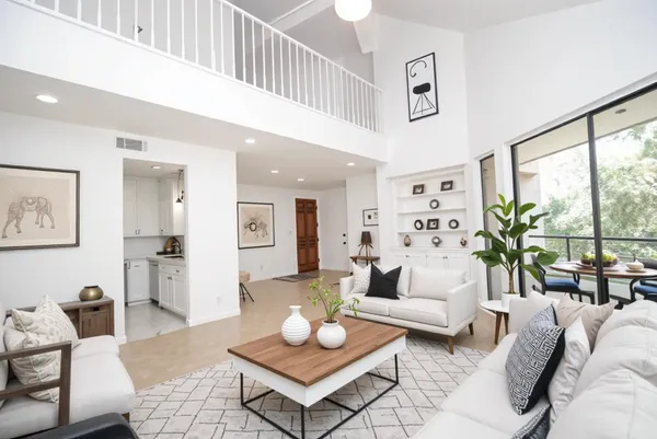 a living room with furniture a rug and a large window