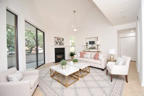 a living room with furniture a fireplace and a large window