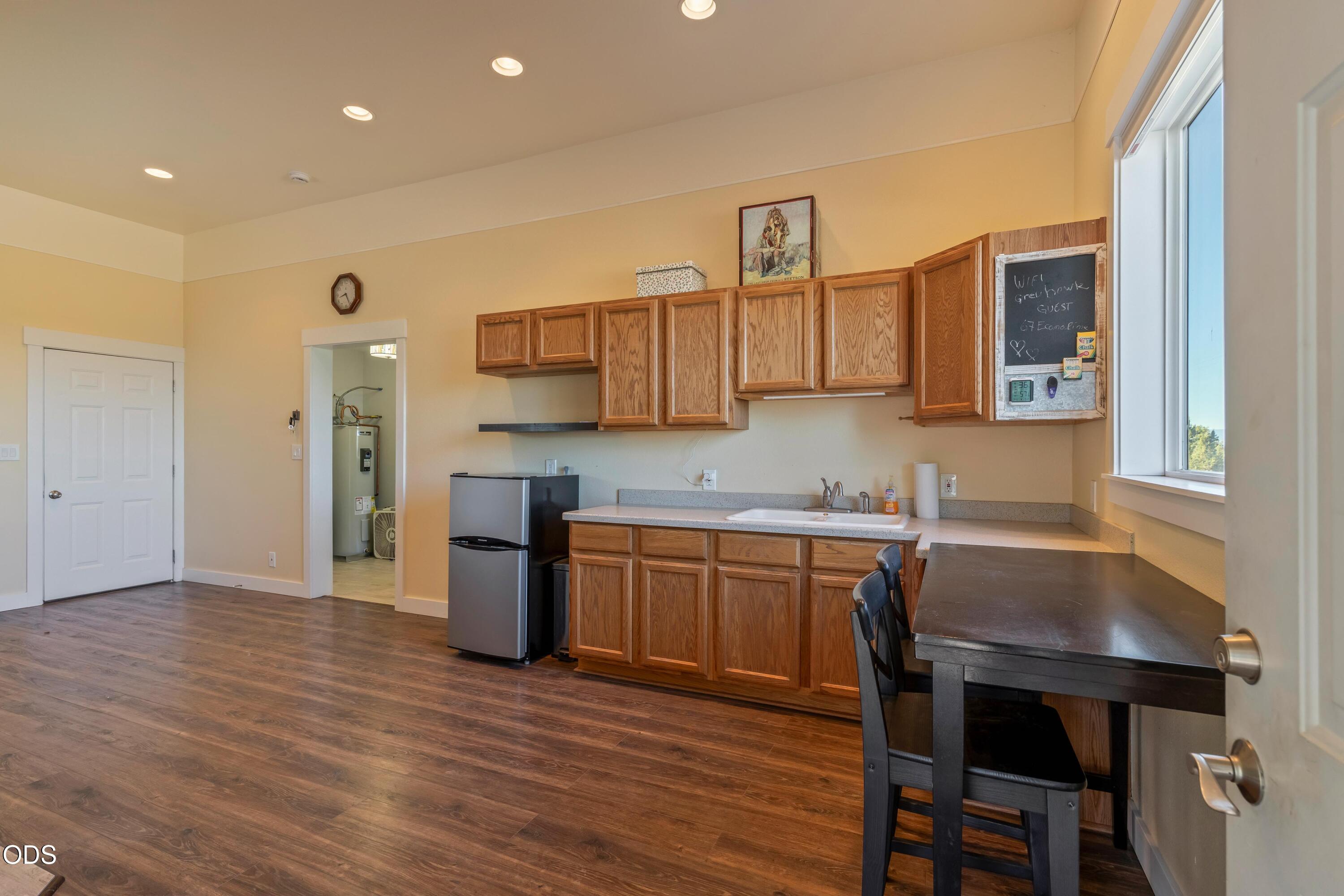 13753 South Sego Lily Road Powell Butte, OR 97753 - Photo 24 of 46 a kitchen with a table chairs sink and cabinets
