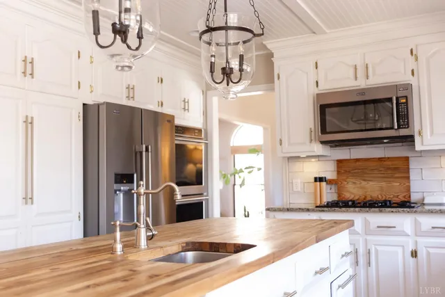 a kitchen with stainless steel appliances granite countertop a refrigerator a stove and a sink