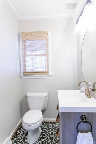 a bathroom with a sink a toilet and a window