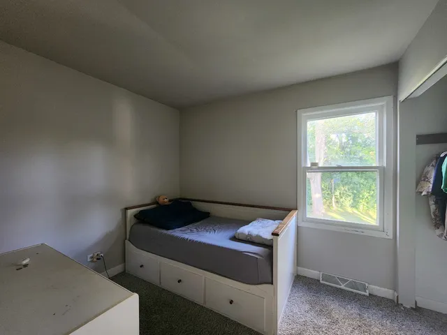 a bedroom with a bed and a window