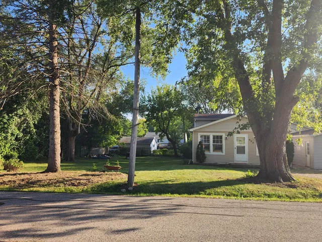 a view of a house with a backyard and tree