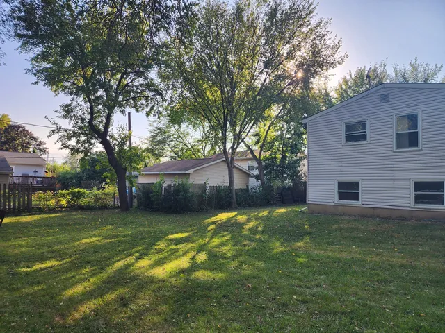 a backyard of a house with large trees and a small yard