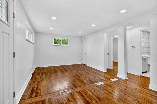 a view of a livingroom with wooden floor and a bathroom