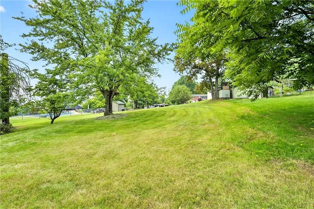 an aerial view of residential houses with outdoor space and trees all around