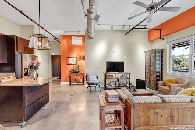 a living room with furniture a flat screen tv and kitchen view