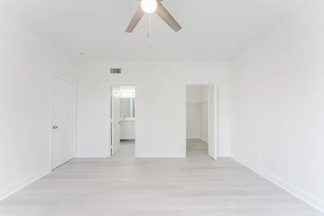 an empty room with a ceiling fan and a window