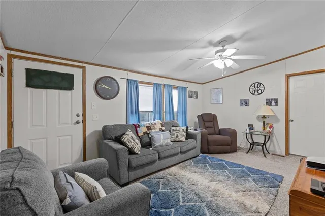 a living room with furniture a clock on wall and a window
